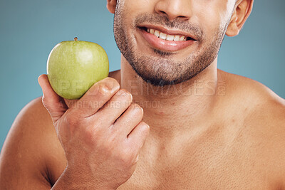 Buy stock photo Man, hands and holding apple on blue background in studio for health, wellness or immune support. Zoom, smile and happy personal trainer with diet fruit for weight loss, wellness or food for workout