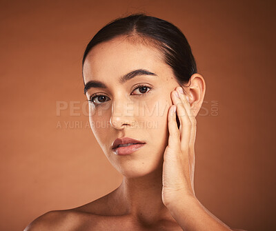 Buy stock photo Cosmetics, skincare and woman touch face for natural beauty, confident and healthy with brown studio background. Portrait, makeup and young girl with pride, wellness or organic facial for smooth skin