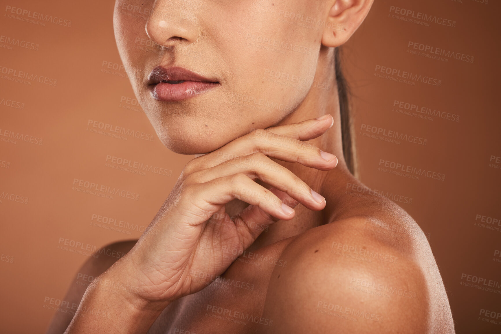 Buy stock photo Hand, lips and woman with glowing skincare on brown studio background with healthy, wellness manicure and self care dermatology. Zoom, beauty model and mouth with lipstick cosmetics or makeup product