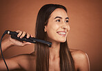 Flat iron woman, hair care studio and beauty cosmetics with smile against brown background. Hair health happiness, hairdresser cosmetic girl and happy hairstyle for wellness self care, tech and heat