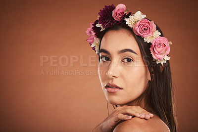 Buy stock photo Face, beauty and flowers with a model woman in studio on a brown background with mockup to promote natural skincare. Wellness, portrait and luxury with an attractive young female wearing a wreath