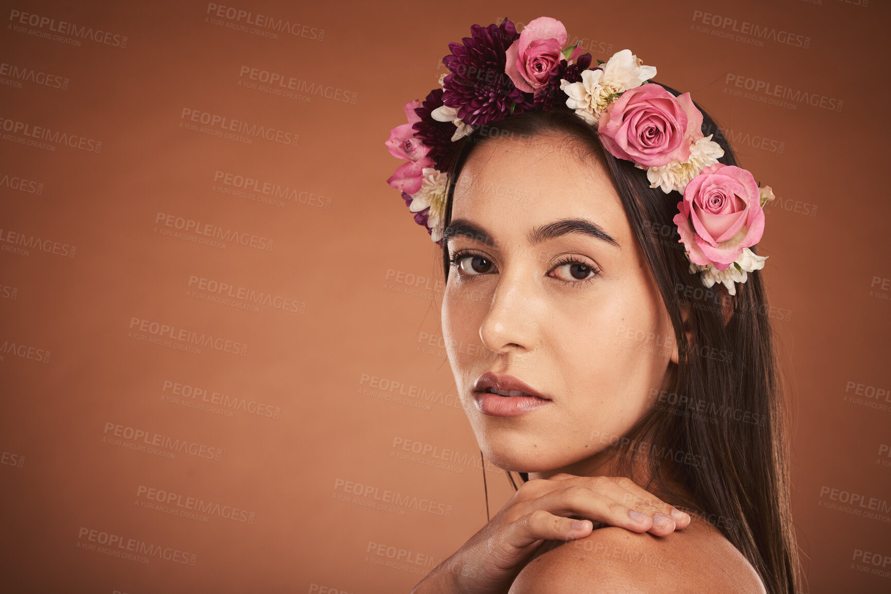 Buy stock photo Face, beauty and flowers with a model woman in studio on a brown background with mockup to promote natural skincare. Wellness, portrait and luxury with an attractive young female wearing a wreath