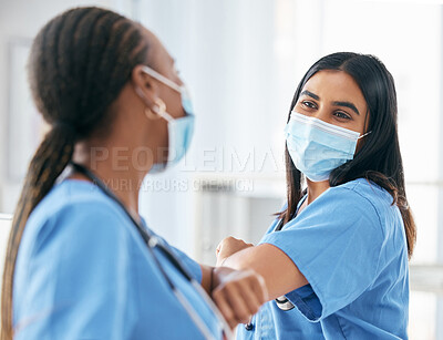 Health, covid and mask, women in hospital safety for healthcare in pandemic and touch elbow for greeting or celebrate. Doctor, team and medical professional with protection in clinic and diversity.