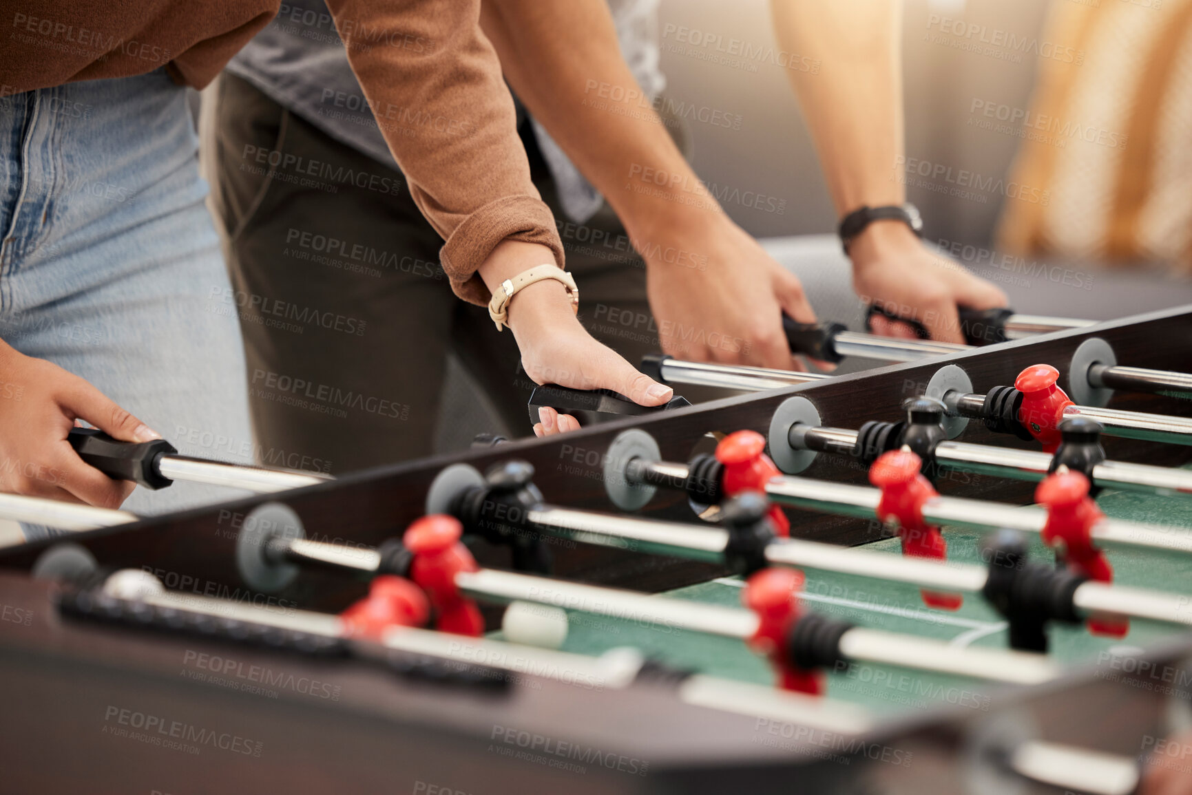 Buy stock photo Hands, foosball and table with friends playing a game together indoors for fun or recreation. Football, fun and leisure with a friend group together to play at a party or celebration event