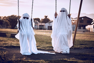 Buy stock photo Park, halloween and friends in a ghost costume in a kids playground in celebration of a scary fantasy holiday. Glasses, creepy and crazy couple in horror, creative and spooky white sheets on a swing