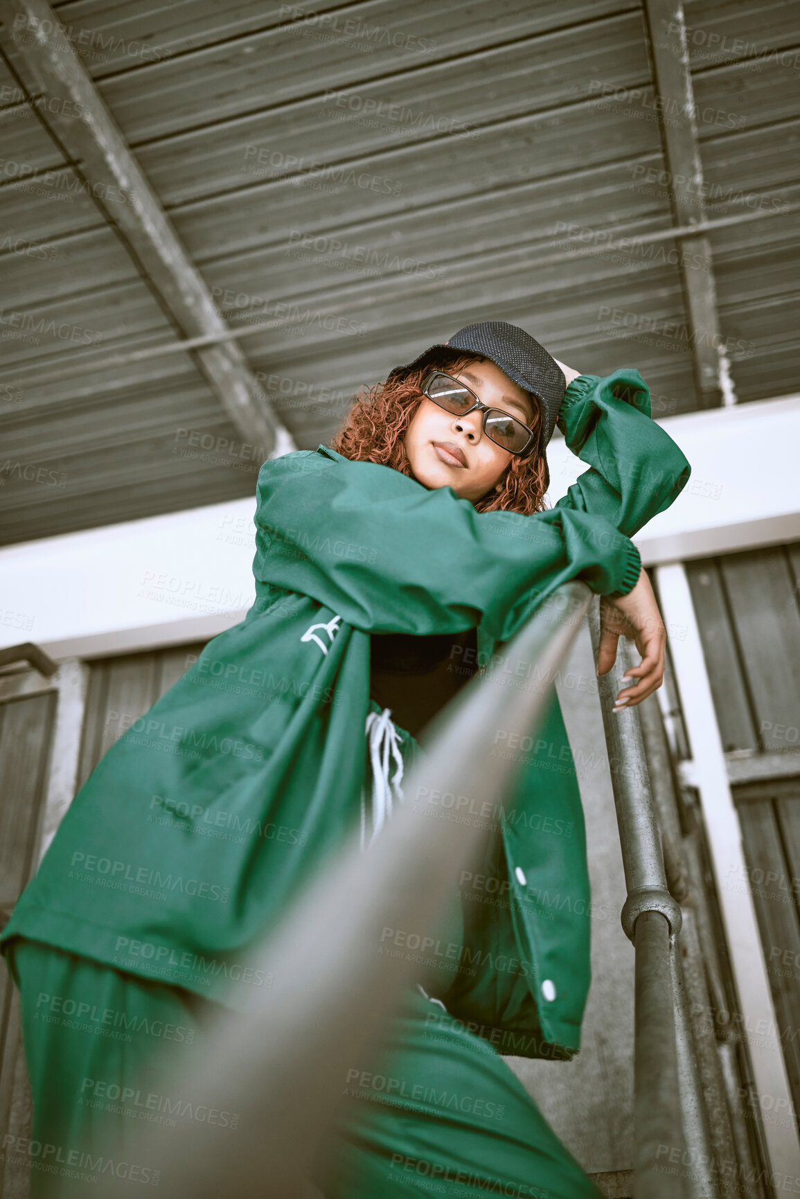 Buy stock photo Fashion, street style and woman with green clothes, sunglasses and hat standing on stairs of an urban city building. Portrait of a cool female, hip hop or fashionable hipster model with casual outfit