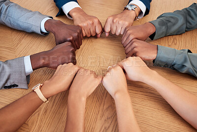 Buy stock photo Diversity, teamwork and circle of hands in fist, aerial view for support, community and unity in workplace. Collaboration, agreement and business people working together in meeting with hand on desk