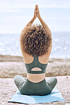 Yoga, zen and back view of black woman at beach on yoga mat outdoors for health, wellness or mobility. Meditation, hands up prayer pose or female training in pilates for exercise, fitness or workout.