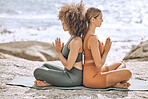 Yoga, meditate and fitness women at the beach, ocean and sea feeling mindfulness and peace. Diversity of relax and peaceful girl friends in nature by the water meditating for spiritual wellness