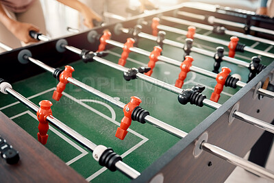 Foosball, game and fun with people playing a game inside of a clubhouse or at a party together. Soccer, table and competition with friends bonding over a match of football together for recreation