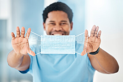 Buy stock photo Covid safety of a healthcare nurse holding a corona face mask with a smile in a hospital. Portrait of a happy doctor, medical and nursing black man worker working in a wellness and health clinic