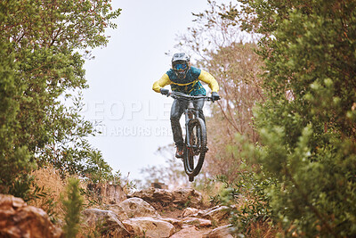 Buy stock photo Mountain bike, sports and fitness with a man adrenaline junkie riding in the woods or forest in nature. Sky, training and exercise with a male athlete on a bike for trail riding or adventure 