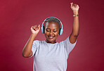 Music, dance and freedom with a black woman in studio on a red background for dancing or fun. Dancer, headphones and carefree with a young female streaming audio with an online service for enjoyment