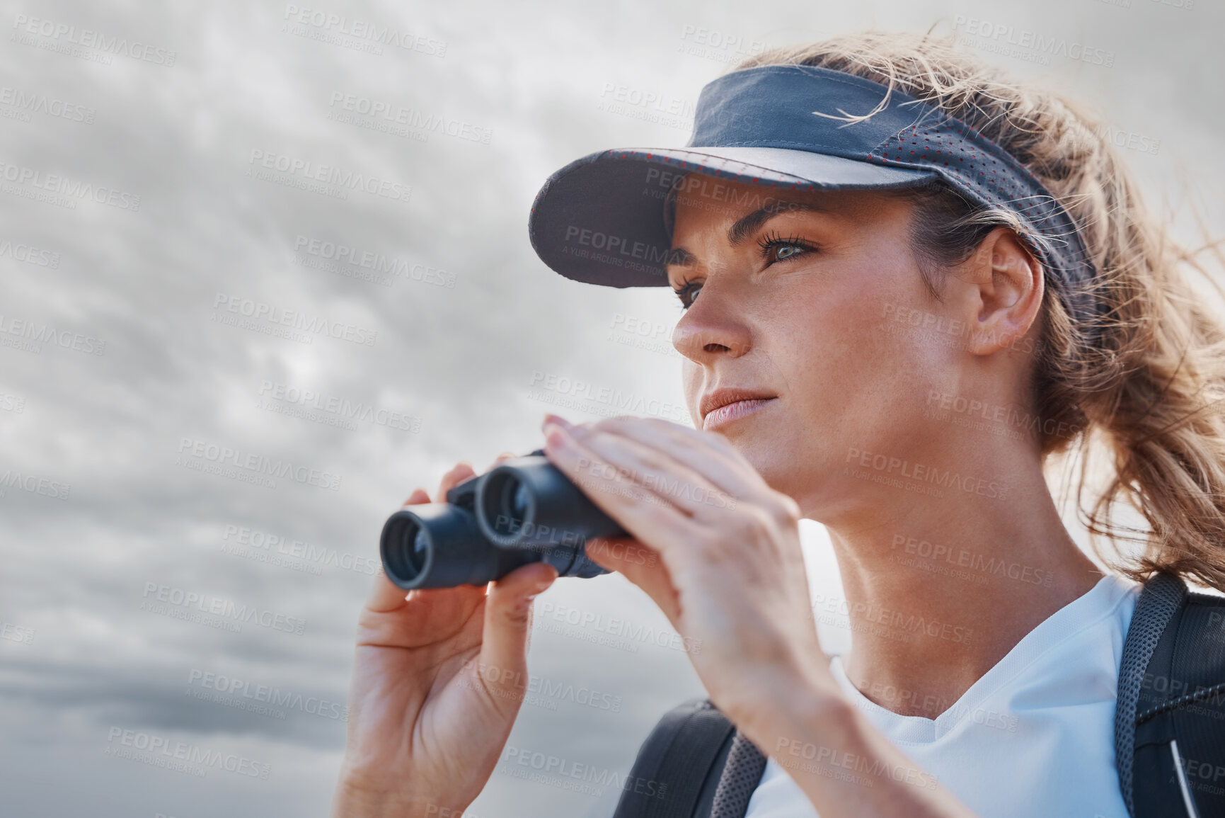 Buy stock photo Woman, binoculars and hiking in nature, travel or outdoors vacation, holiday or trip in Canada. Freedom, cloudy sky and female on adventure, sightseeing or trekking and looking with field glasses.