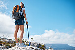 Mountain, hiking and woman on top of the mountain during an adventure journey in africa. Freedom, blue sky and girl standing on a cliff while trekking in nature on a summer with a pole and backpack