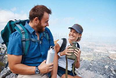 Buy stock photo Hiking, couple and water bottle with smile, conversation and happy together outdoor in nature. Hike, man and woman on mountain range, break, relax and bonding being loving and laugh with fresh air.