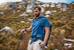 Blur motion, hiking and man on outdoor for health, wellness and on mountain range with stick for balance. Nature, healthy male and hiker enjoy walking, exercise and natural space for adventure. 