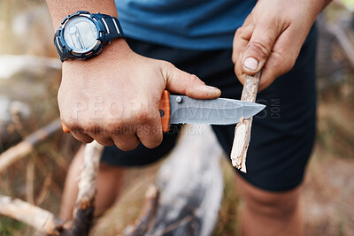 Buy stock photo Hands, knife and cutting with a hiking man carving a stick outdoor in nature while camping for adventure. Wood, weapon and tool with a male camper slicing a twig in the mountains for survival