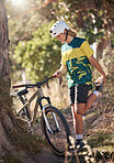 Bike, nature and stretching with a man cyclist in the mountains for exercise, cardio or adventure. Fitness, sports and cycling with a male athlete warming up with his bicycle in the forest or woods