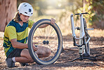 Mountain bike cycling, tire repair and man check, fix or does maintenance on broken or damaged bicycle wheel. Fitness workout, training exercise and adventure man fixing travel bike in nature forest