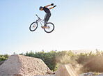 Bike, man and extreme jump at park, with safety gear and outdoor for rush, competition and training for routine. Bicycle, male athlete and practice for fitness, contest and motivation for tournament.