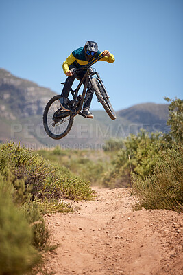 Buy stock photo Bike, bmx and fitness with a man biker on a dirt trail or track taking a jump with a mountain bike. Sky, nature and cycling with a mountain biker jumping in midair while riding outdoor for adrenaline