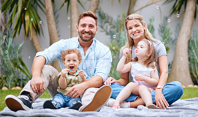 Buy stock photo Bubbles, garden and portrait of parents with children having fun on weekend, holiday and relaxing. Family, love and mom and dad with kids sitting on grass in backyard doing cute outdoor activity