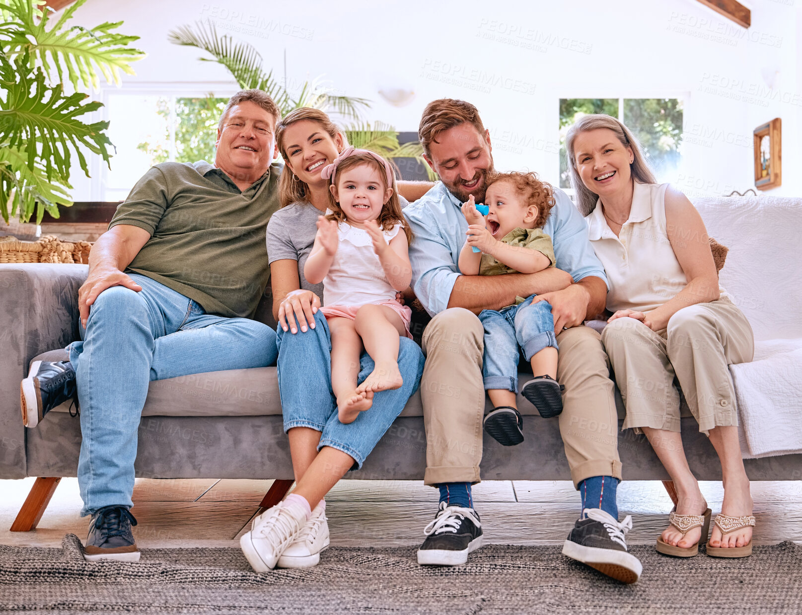 Buy stock photo Children, parents and happy grandparents on sofa, generations of family together in living room. Love, home and couple with kids, grandma and grandpa in Canada relax and smile on couch in family home