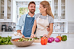 Love, health and happy couple cooking in the kitchen with healthy food or vegetables for lunch or dinner. Smile, house and happy woman enjoys salad preparation with a hungry vegan partner in Sydney