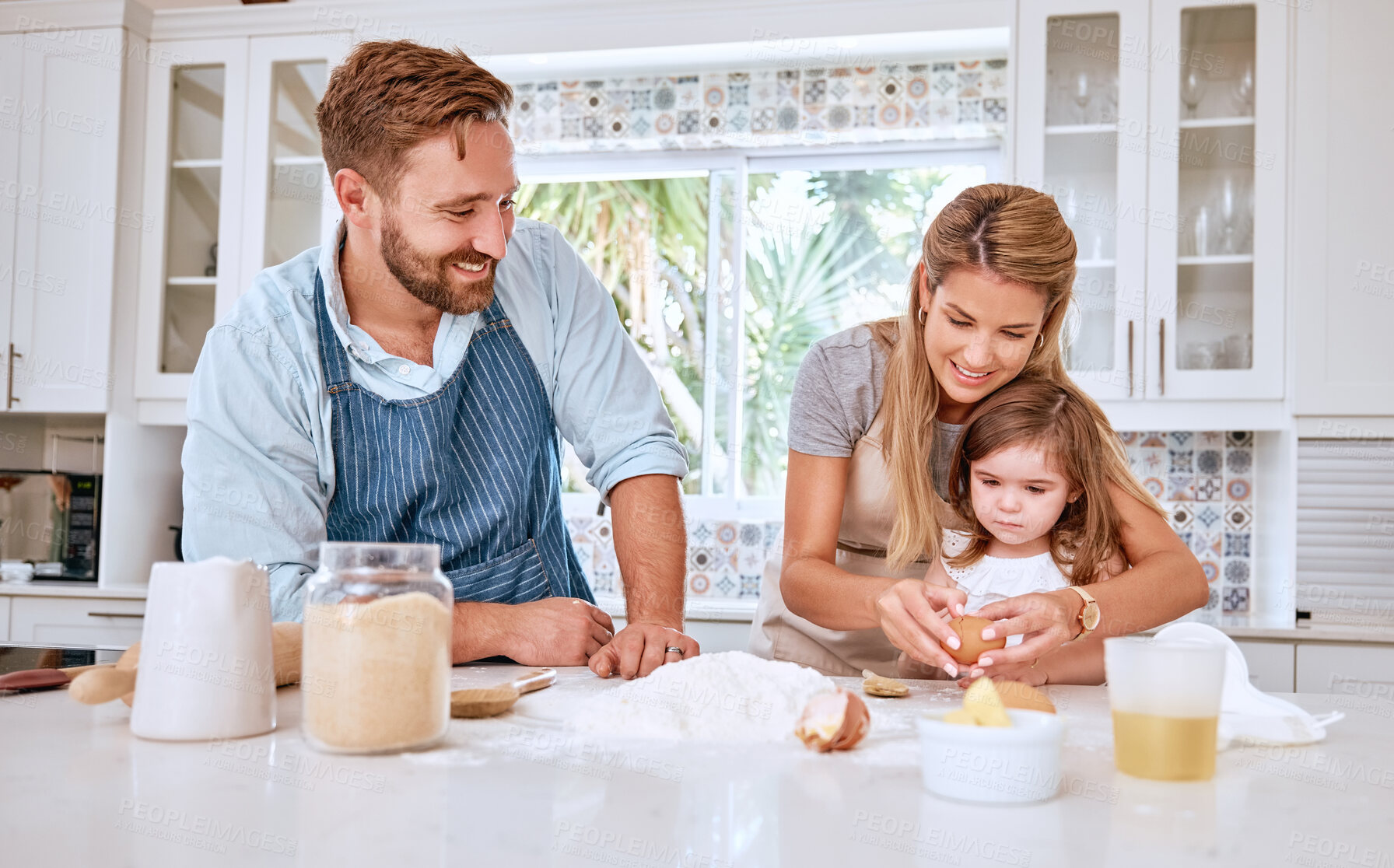 Buy stock photo Mother, father and girl cooking and baking in kitchen having fun, bonding and together. Family, love and parents teaching child to cook, bake and learning chef skills at home for child development