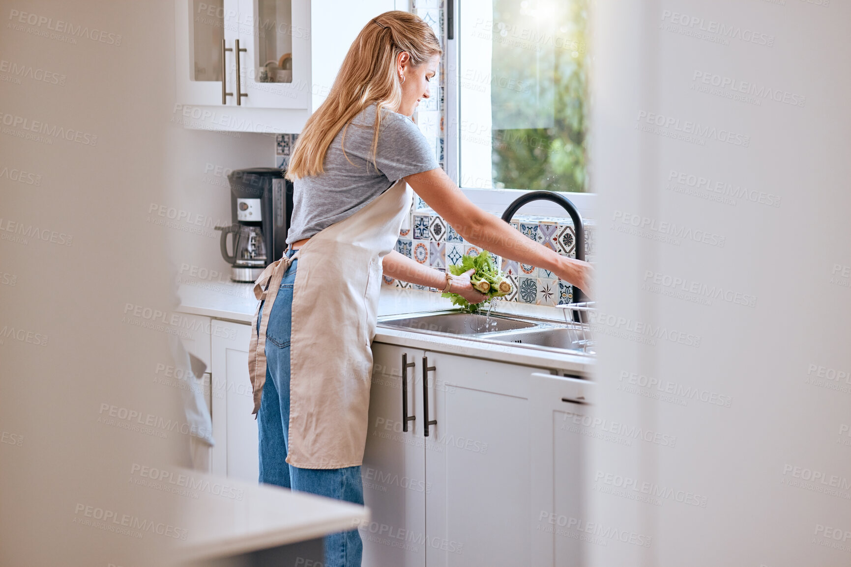 Buy stock photo Woman, cooking and cleaning food or vegetable with water under kitchen tap for healthcare, wellness and safety home. Female chef or housewife with green lettuce for salad, lunch or dinner for diet