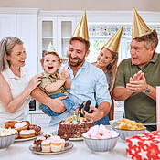 Baby, birthday party and family celebration at a kid event with mother ...