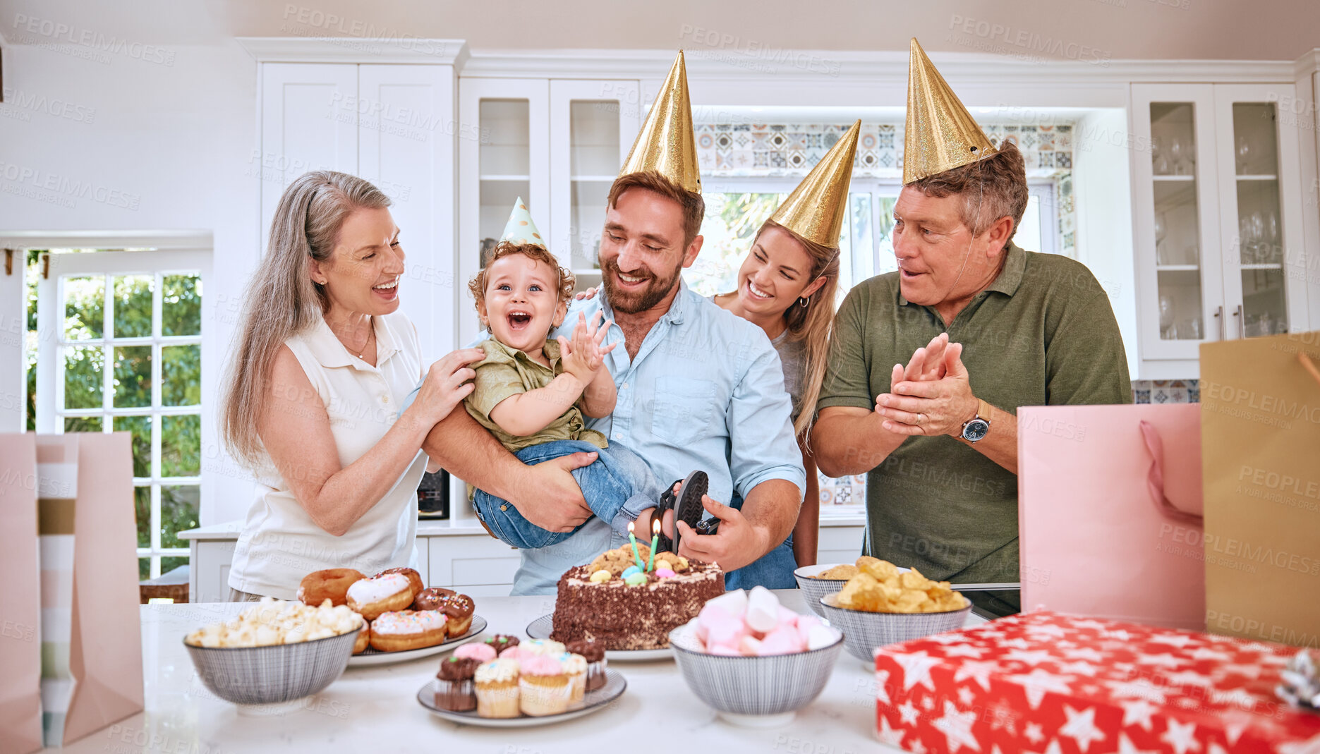 Buy stock photo Baby, birthday party and family celebration at a kid event with mother, father and friends. Young child and parents celebrate event with food clapping for a happy boy in a family home kitchen