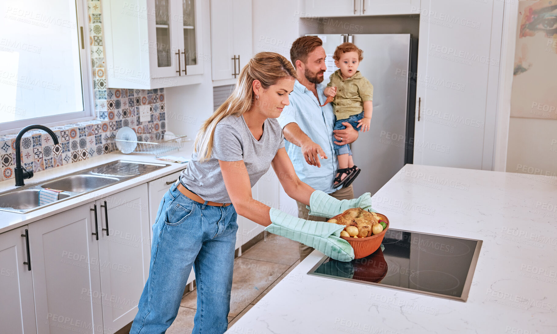 Buy stock photo Family, cooking and home kitchen with a mother, father and child waiting for dinner, food and a healthy meal. Man, woman and baby in house for bonding, eating and nutrition with roasted chicken