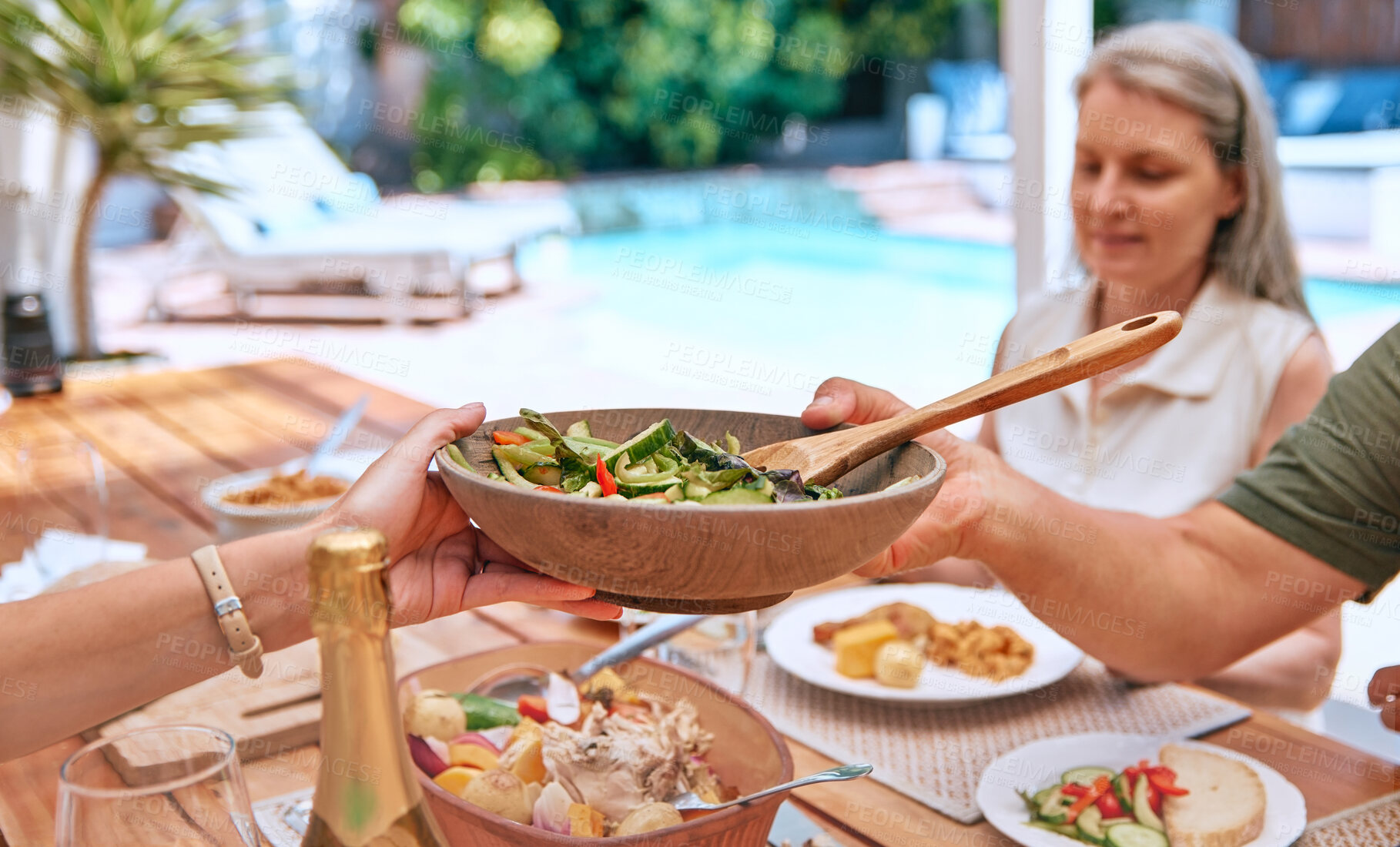 Buy stock photo Hands, food and family relax on a patio, eating, bond and sharing a meal at a table together. Friends, salad and senior woman calm, content and enjoy healthy lunch with hungry group on a terrace