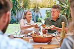 Bbq, lunch and family in the garden for a celebration, relax and happy in summer together. Food, picnic and senior man and woman at a barbecue party with their children in a backyard of their house