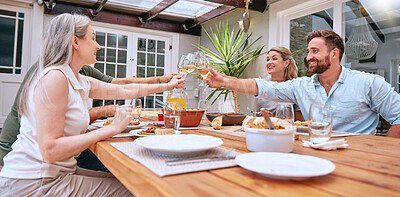 Friends, wine and celebration toast with family to celebrate holiday with lunch party, food and wine at patio table. Men and women couple drinking alcohol together and happy while talking home