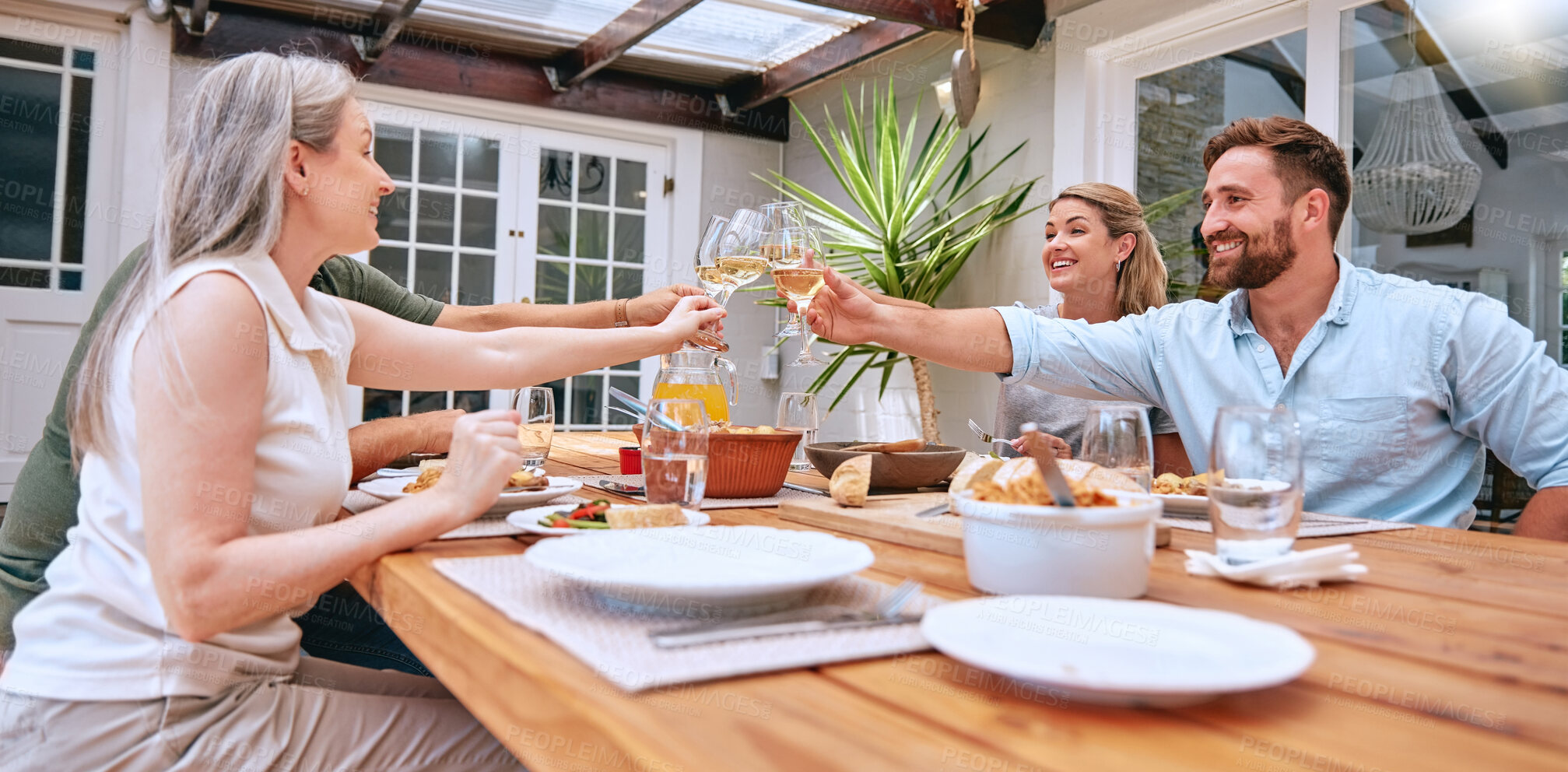Buy stock photo Friends, wine and celebration toast with family to celebrate holiday with lunch party, food and wine at patio table. Men and women couple drinking alcohol together and happy while talking home