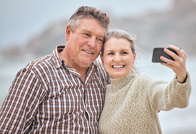 Buy stock photo Phone, selfie and beach with a senior couple taking a photograph while on holiday or vacation travel together. Mobile, summer and retirement with a man and woman posing for a picture at the coast