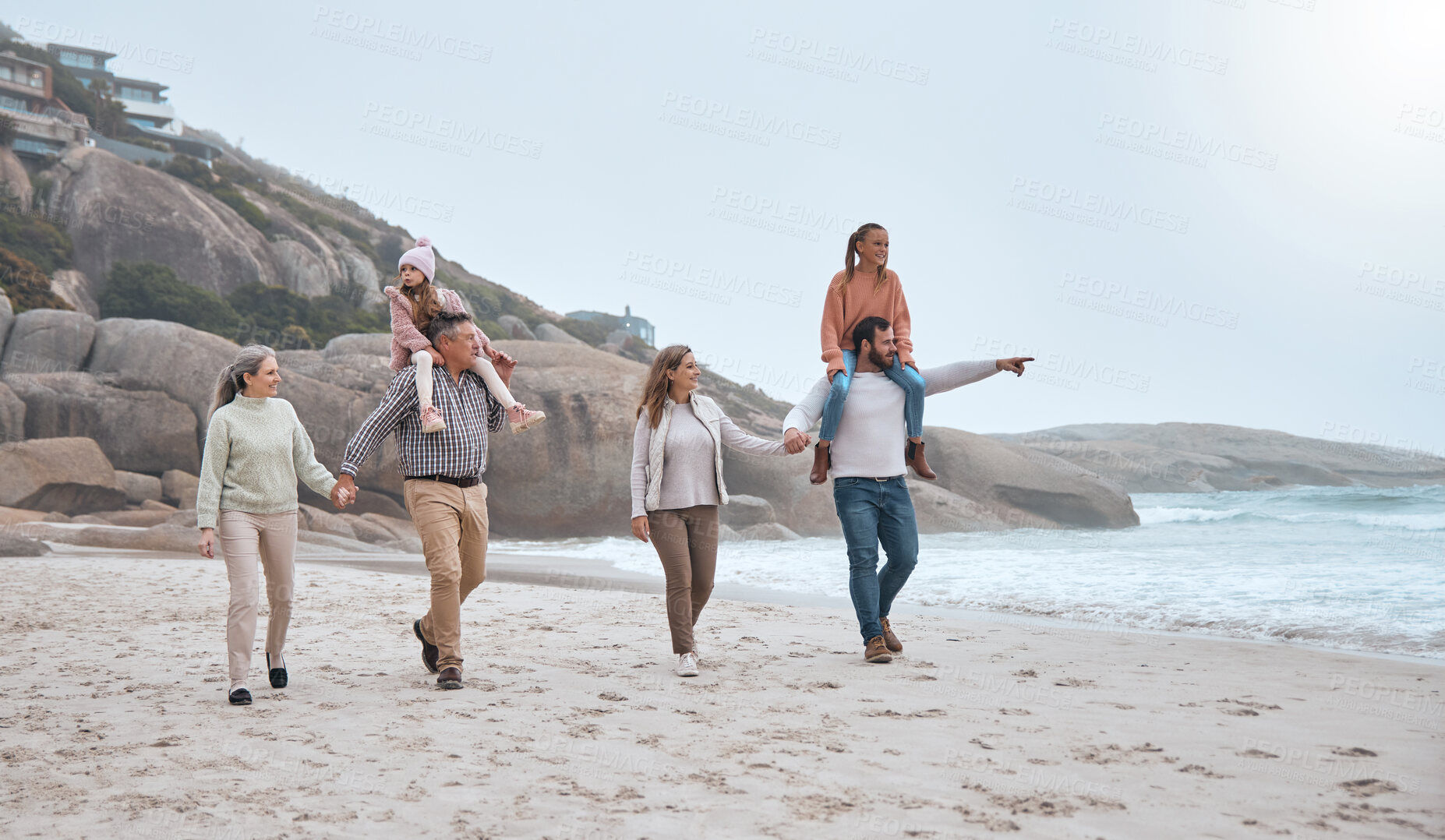 Buy stock photo Big family, beach and walking for bonding with generations in winter by the sea water. Mother, father and grandparents together being loving and caring while on holiday or vacation for relaxation 