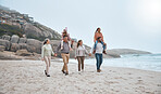 Family, walking and holding hands on beach holiday vacation. Happy grandparents, parents and children smile together for love trust bonding holiday or quality time adventure on sand ocean water
