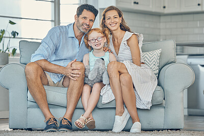 Buy stock photo Happy, smile and portrait of a family on a sofa to relax and bond together in the living room of their home. Happiness, mother and father sitting with their girl child on couch in their modern house.