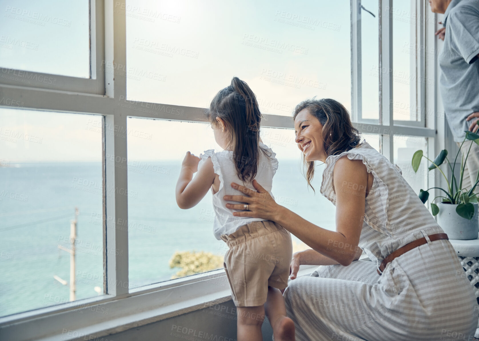 Buy stock photo Family view, window and mother with child bonding, having fun and enjoy quality time together in home living room. Mama's love, happiness and mom with kid girl watch the ocean through glass window