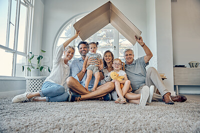 Buy stock photo Big family, children and insurance with a mother, father and grandparents sitting under cardboard in the living room in home together. Kids, love and cover with parents and senior people in house