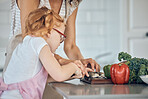 Mother teaching, child cutting vegetable and learning life skill in home kitchen together on counter. Girl knife focus, cooking education with mom teacher and cut vegetables for dinner food in house