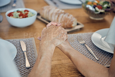Buy stock photo Family, food and prayer with senior couple holding hands, paying and gratitude at dining table for lunch, dinner and healthy diet. Man and woman saying grace, religion and grateful to pray and eat 