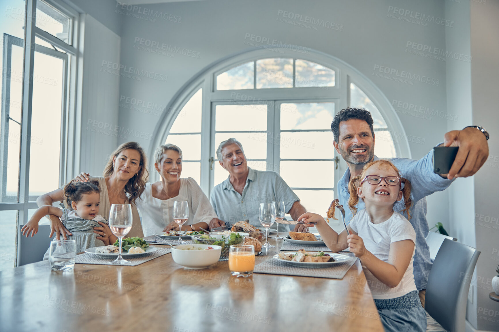 Buy stock photo Grandparents, parents and children taking a selfie at dinner, eating meal together on weekend. Big family, love and dad holding smartphone for picture enjoying lunch, supper and holiday celebration