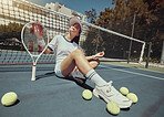 Tennis, sports and exercise with a woman athlete sitting on a court with a racket and balls after a game. Fitness, sport and training with an attractive young female tennis player after a match