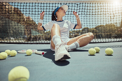 Woman, relax and tennis court net with tennis ball, ground and rest at training, workout or practice. Girl, tennis and tired on court for sport while sitting, outdoor or fitness in summer sunshine