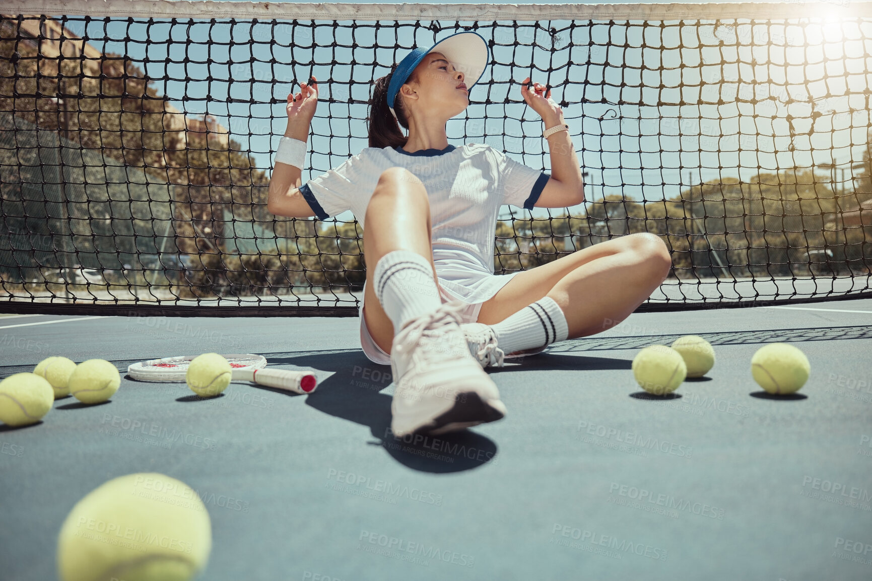 Buy stock photo Woman, relax and tennis court net with tennis ball, ground and rest at training, workout or practice. Girl, tennis and tired on court for sport while sitting, outdoor or fitness in summer sunshine